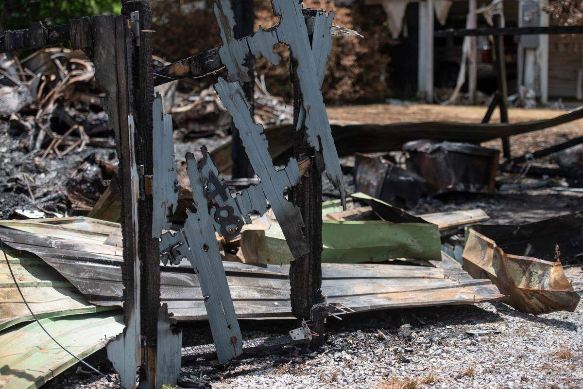 Part of a house number on a fence is all that remains of one of two houses that caught fire Saturday night on Highway 603 in Kiln.