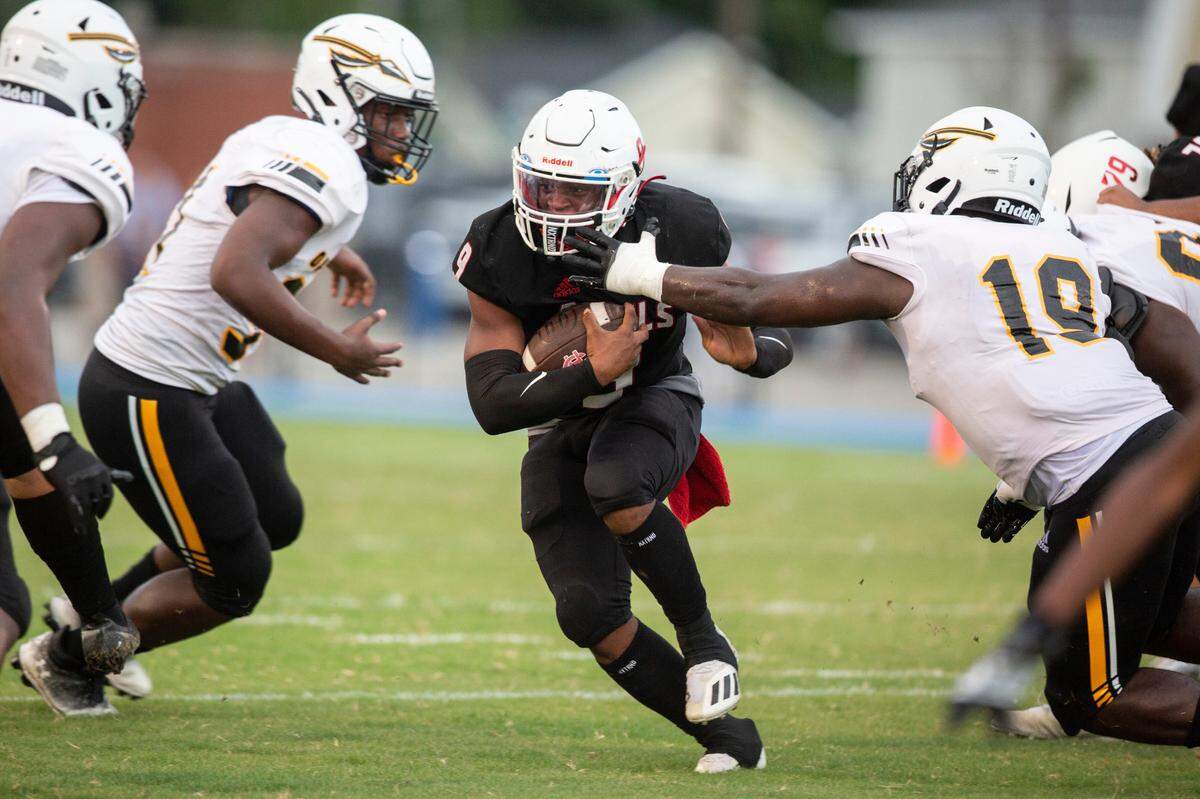 Harrison Central’s running back Des Smith runs past Oak Grove players during a game against Oak Grove at Milner Stadium in Gulfport on Friday, Aug. 26, 2022.