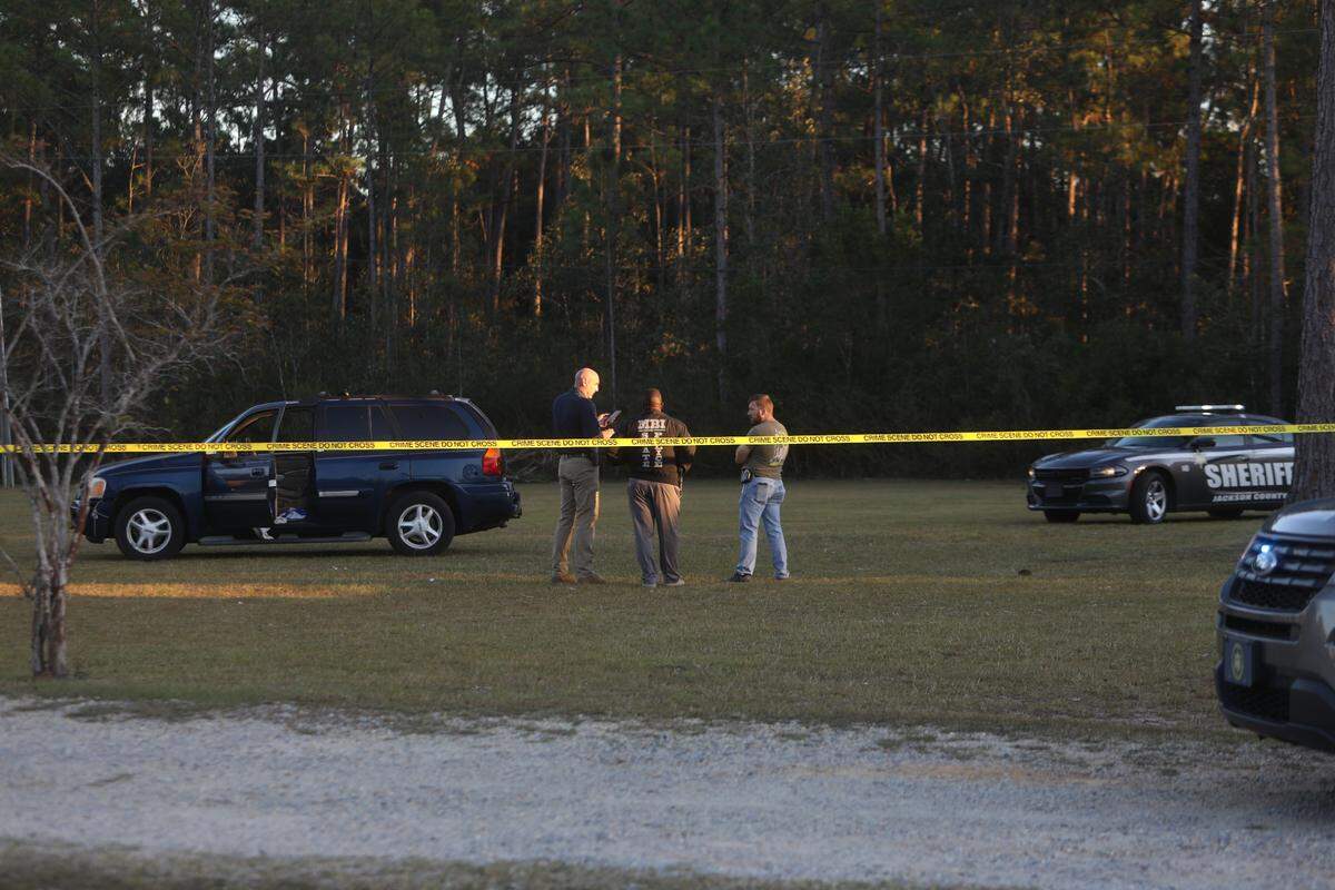 Members of the Mississipp Bureau of Investigation and the Jackson County Sheriff’s Office stand near a blue SUV that came to a stop in the front yard of a residence on Old Biloxi Road in the Latimer Community after a police pursuit on October 19, 2022.