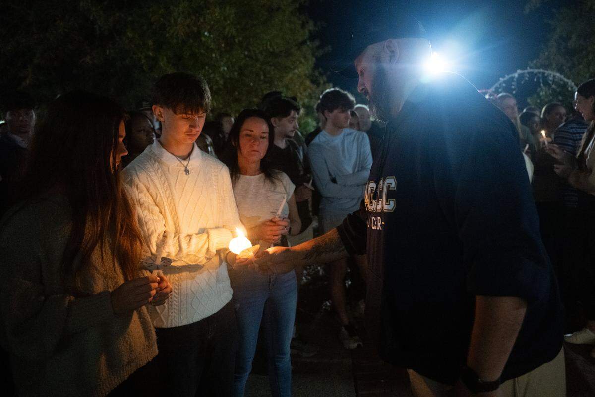 Josh Perry, Landon Perry’s father, lights the candles of attendees.