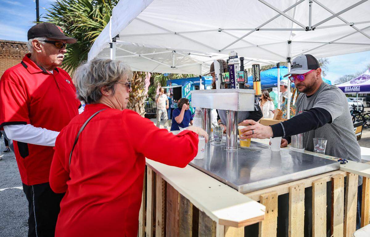 David Reese owner of Fly Llama Brewery in Biloxi that opened in January, serves beers at the District Green in Downtown Biloxi. A block party kicked off the first event at the outdoor space Friday, March 5, 2021. .