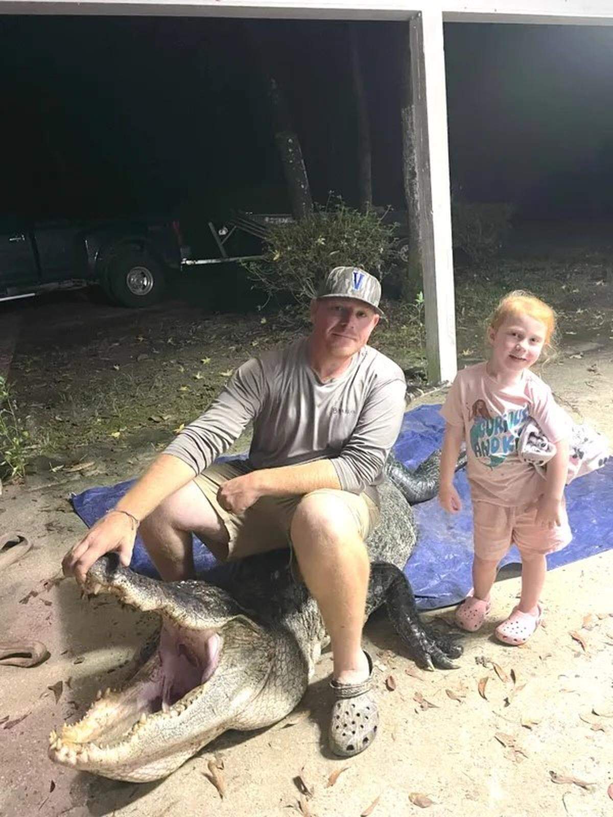 Justin Ely and daughter Piper, 4, pose with an alligator Ely and fellow hunter Matt Richardson, both of Vancleave, caught after a chaotic fight.