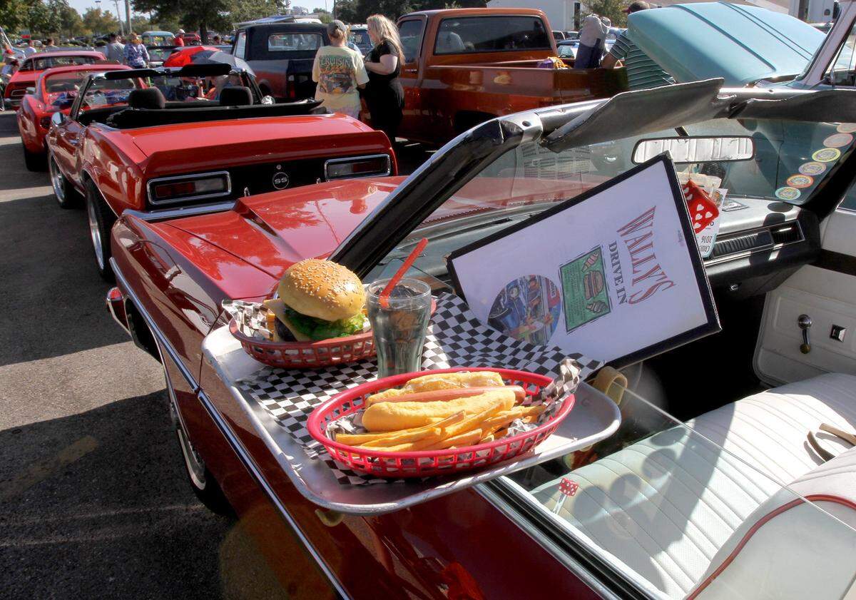 A Caprice Classic is outfitted with a diner burger and fries at the Long Beach parade, which always rolls Monday during Cruisin’ The Coast.