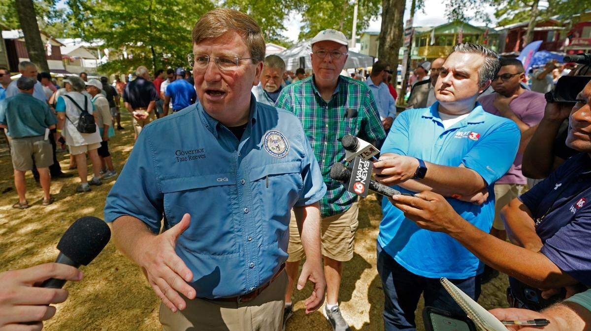 Republican Gov. Tate Reeves speaks with reporters after his address at the pavilion in Founders Square at the Neshoba County Fair in Philadelphia, Miss., Thursday, July 28, 2022. The fair, also known as Mississippi’s Giant House Party, is an annual event of agricultural, political, and social entertainment at what might be the country’s largest campground fair. (AP Photo/Rogelio V. Solis)