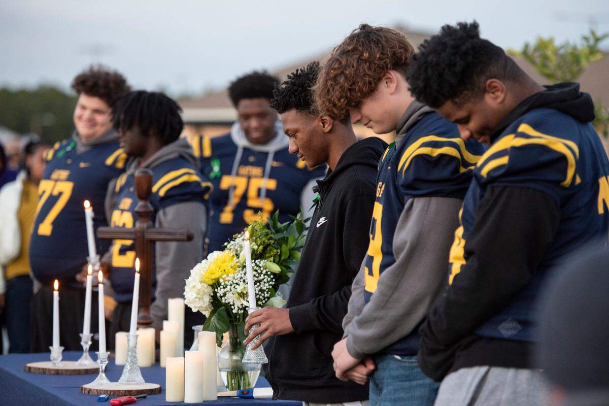 Shermarion Miner’s friends and teammates on the football team light listen to stories about Miner during a vigil for the Gautier High School student at Gautier High School on Thursday, Jan. 16, 2025. Miner died suddenly after working out in the high school field house.
