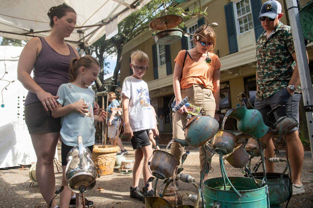 Patrons admire metal fountains for sale during the Peter Anderson Festival in Ocean Springs on Sunday, Nov. 6, 2022.