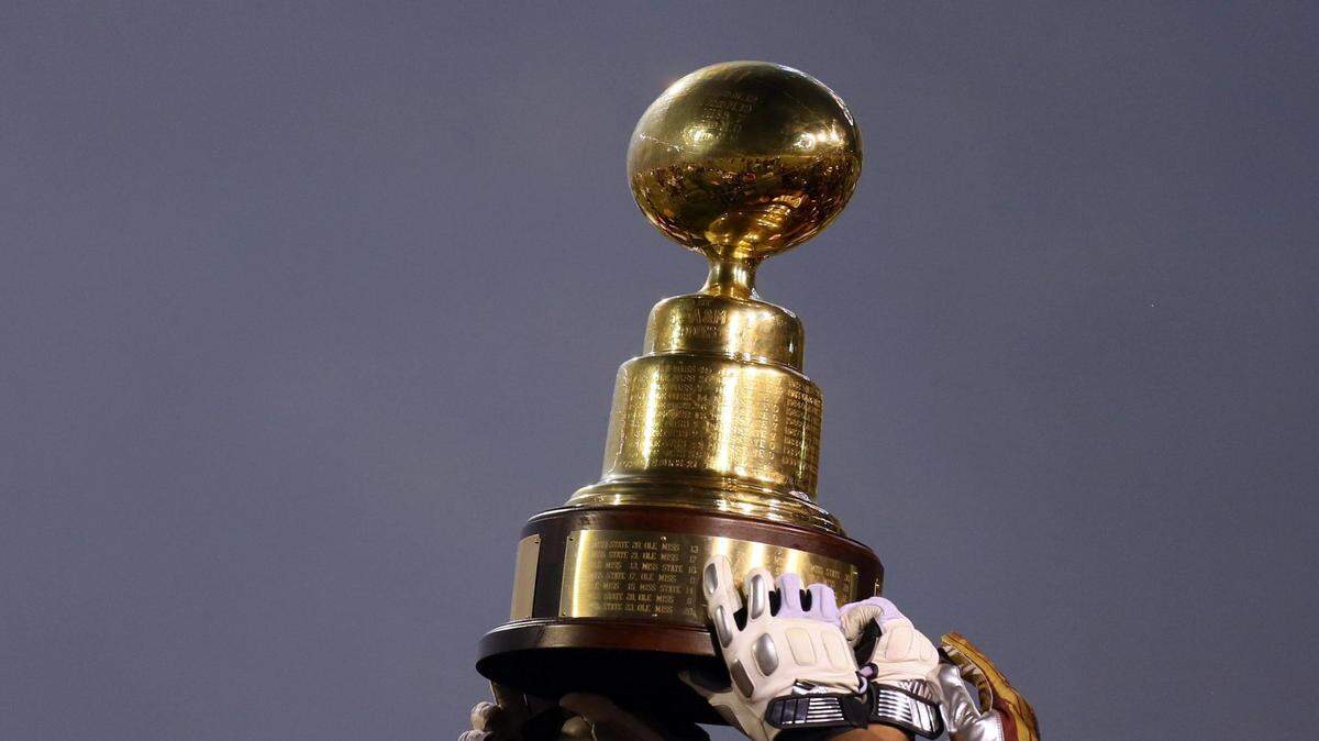 Nov 28, 2013; Starkville, MS, USA; Mississippi State Bulldogs players hold up the egg bowl trophy after winning the game against the Mississippi Rebels at Davis Wade Stadium. Mississippi State Bulldogs defeat the Mississippi Rebels with a score of 17-10 in overtime.  Mandatory Credit: Spruce Derden-USA TODAY Sports
