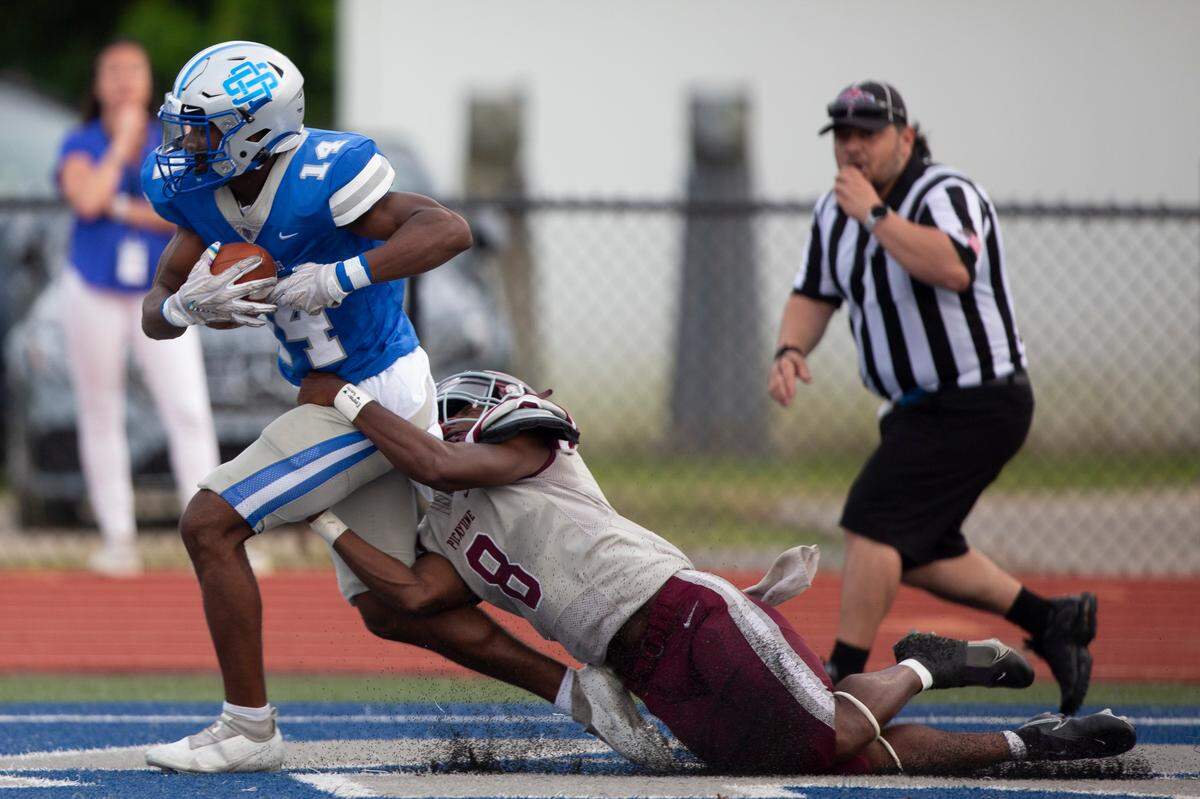 Ocean Springs John Paul Coulter, left, runs the ball into the endzone during a spring game at Greyhound Stadium in Ocean Springs on Friday, May 13, 2022.