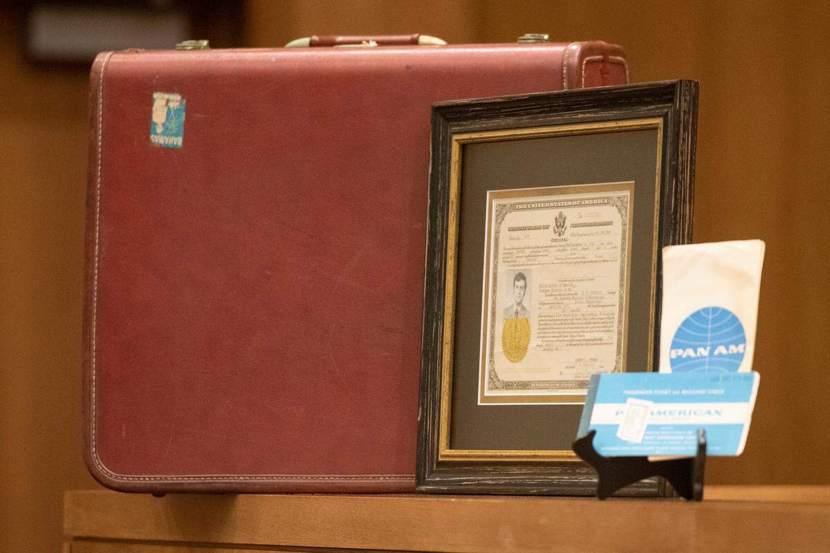 The suitcase and plane tickets U.S. District Judge Halil Ozerden’s father carried with him when he immigrated from Turkey sit on the bench with his naturalization documents during a naturalization ceremony at Dan M. Russell Jr. Federal Courthouse in Gulfport on Friday, Oct. 7, 2022.