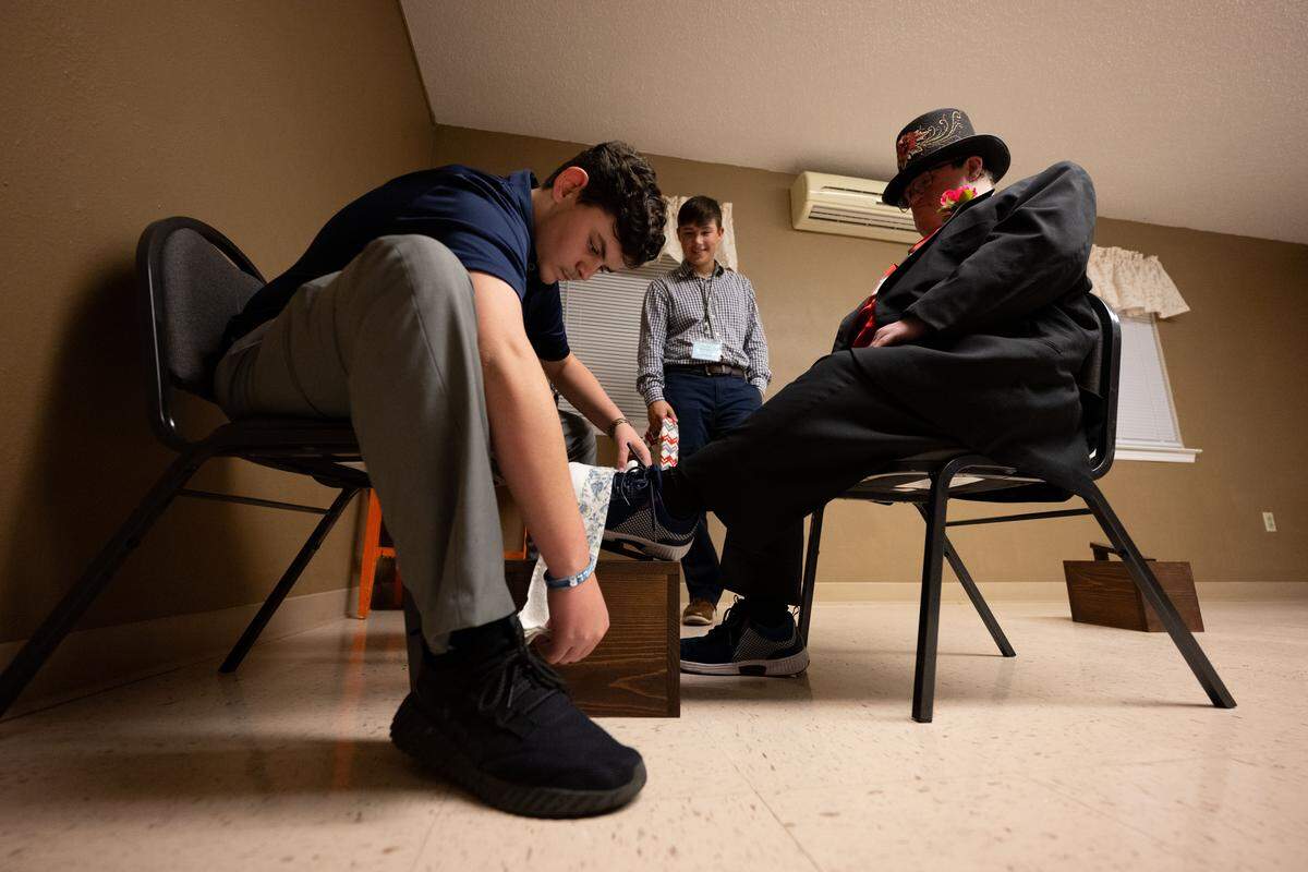 Guests of honor have their shoes shined by volunteers during Night to Shine at Woolmarket Baptist Church on Friday, Feb. 13, 2026.
