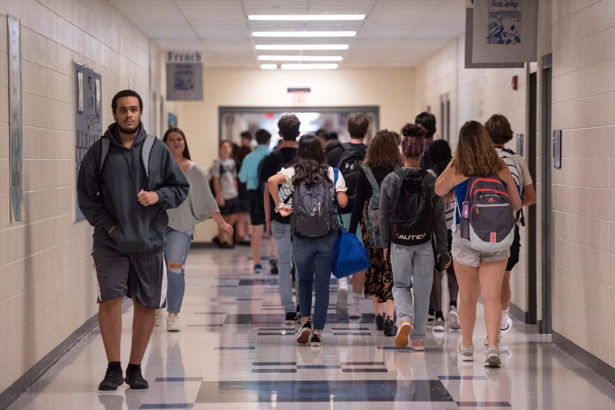 Ocean Springs High school students walk to class on the first day of school in this file photo. High school students will be able to use cell phones and electronics between class and at lunch, but not in the classroom.