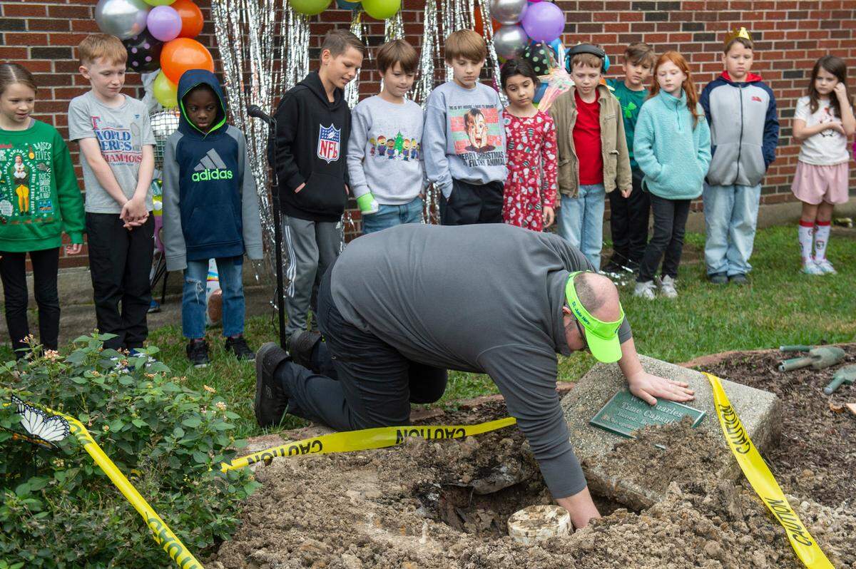 Colby Holland, 35, a former student at W. J. Quarles Elementary in Long Beach, helps to dig up a time capsule on Friday, Dec. 13, 2024, that he and his classmates buried in 1999.