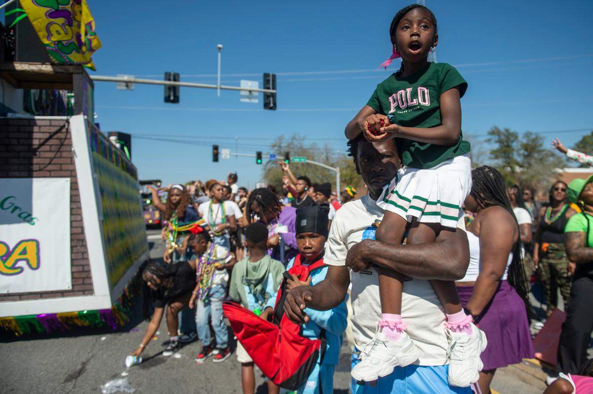 Parade attendees try to catch beads during the Jackson County Carnival Association Mardi Gras parade in Pascagoula on Saturday, March 1, 2025.