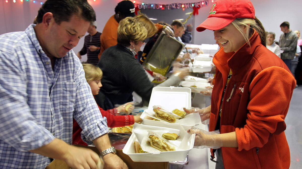 WILLIAM COLGIN/SUN HERALD/FILESteve Fitzgerald and Natalie Mitchell, right, dish up a plate for Amber Peterson during a previous Feed the Needy meal program. This year's Gulf Coast Public Safety Feed the Needy Program will begin packaging meals at 8 a.m. Christmas Day at the Lyman Community Center, 13472 U.S. 49, Gulfport. Deliveries will begin at 9 a.m.
