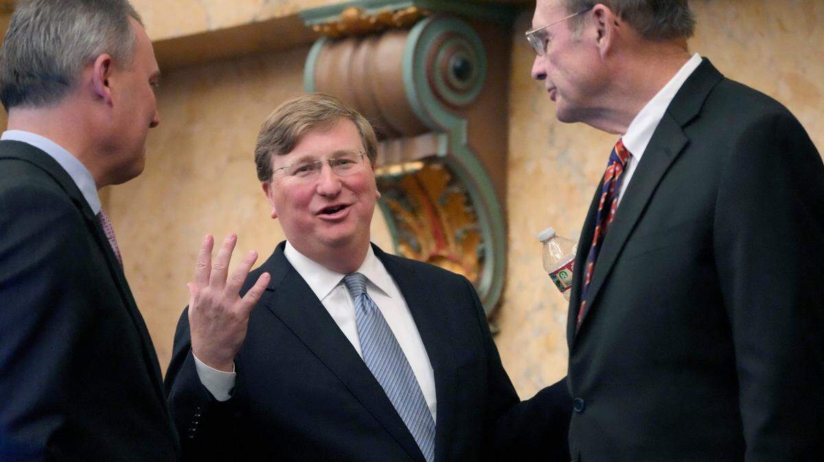 Mississippi Republican Gov. Tate Reeves, center, confers with Mississippi House Speaker Jason White, R-West, left, and Republican Lt. Gov. Delbert Hosemann, after his State of the State address Monday.