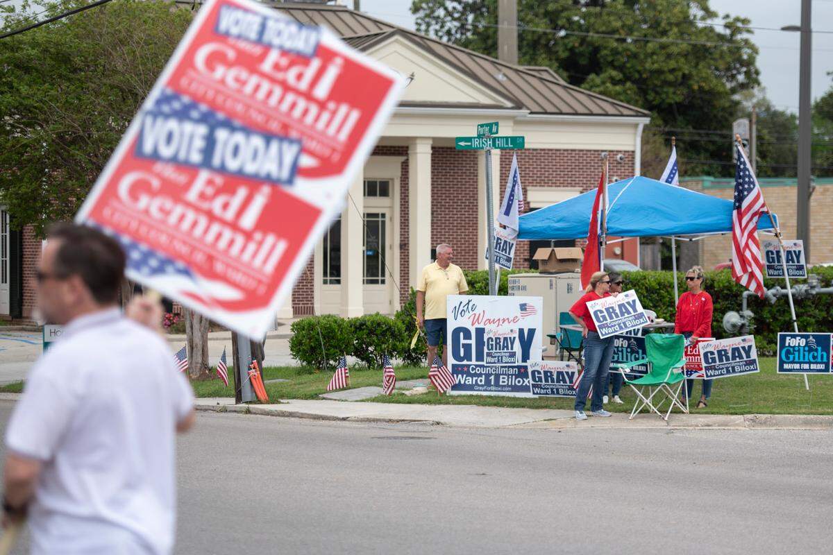 Supporters hold campaign signs across the street from a polling location at Lopez-Quave Public Safety Complex on Tuesday, April 1, 2025.