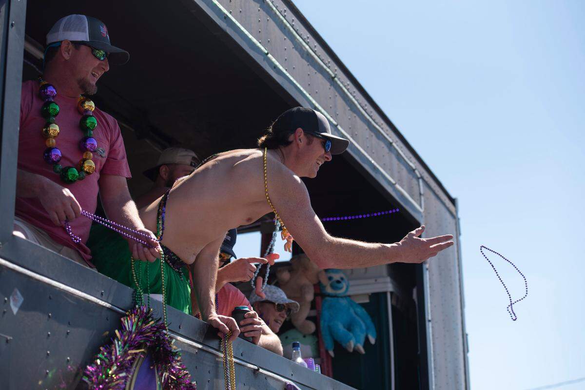 Krewes toss beads and other throws during the Jackson County Carnival Association Mardi Gras parade in Pascagoula on Saturday, March 1, 2025.