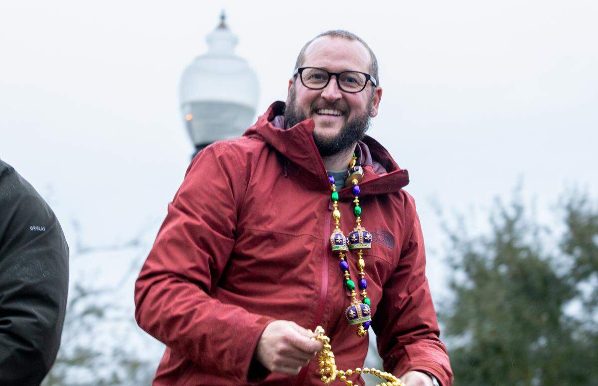 Michael Levens, who will be crowned King Scott at Friday’s coronation ball for the Carnival Association of Long Beach, prepares to throw beads to the crowd at the Jeep-A-Gras parade.