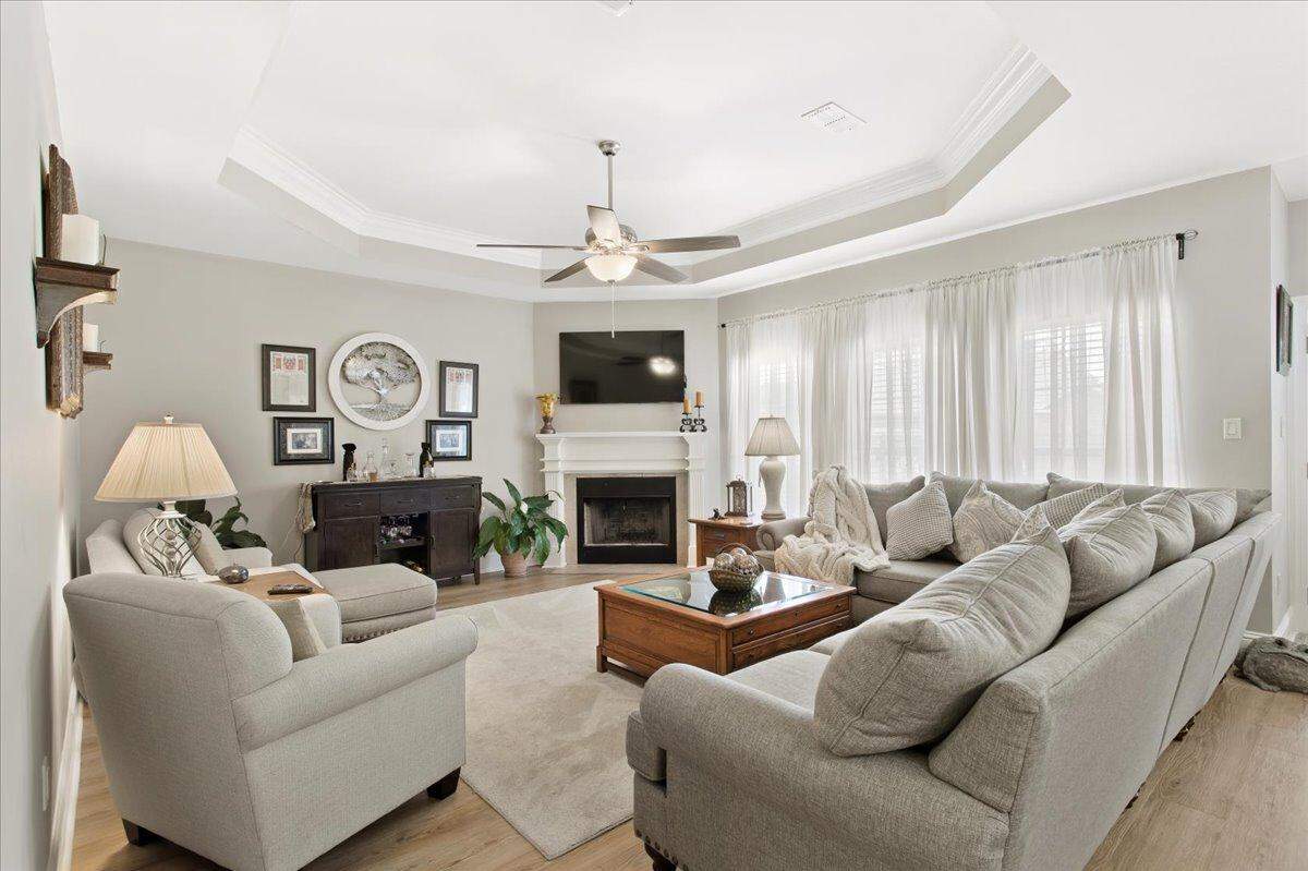 The great room of this house in Ocean Springs features vinyl plank flooring, a tray ceiling and a wood-burning fireplace. A bonus room is located upstairs in the three-bedroom, two-bath house.