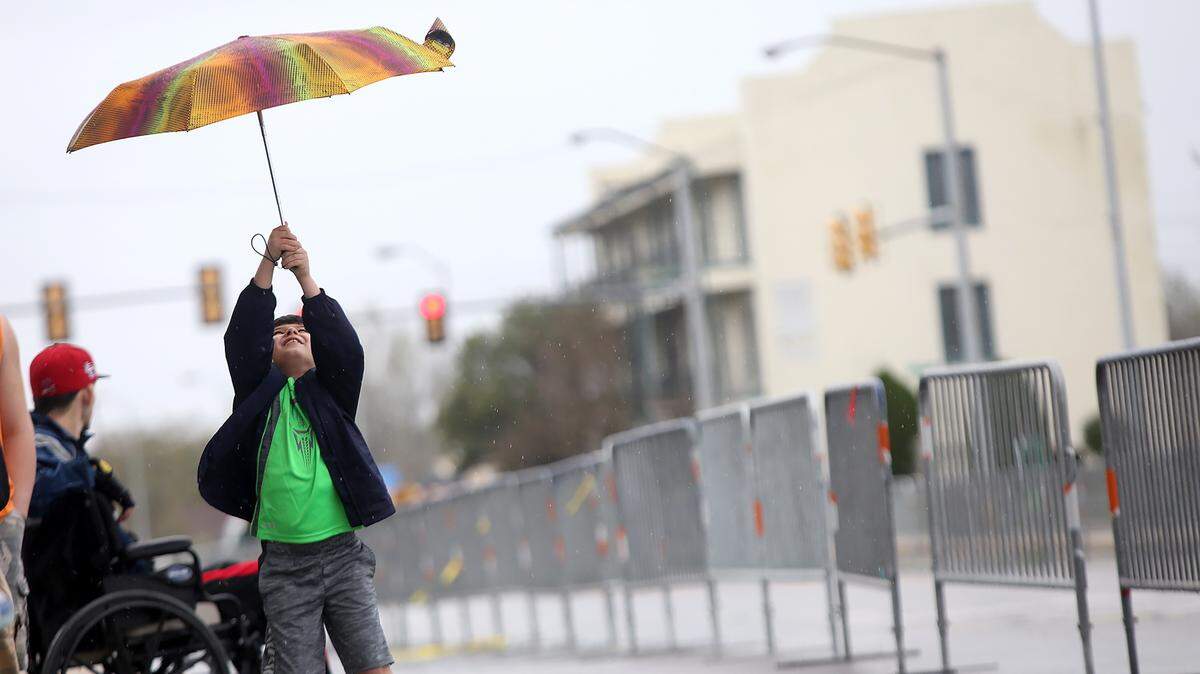AMANDA McCOY/SUN HERALD 
 Nathan Lambert, 7, plays with his umbrella while waiting for Biloxi's Hibernia Parade on Saturday, March 12, 2016. The parade rolled even though rains kept the crowd small.