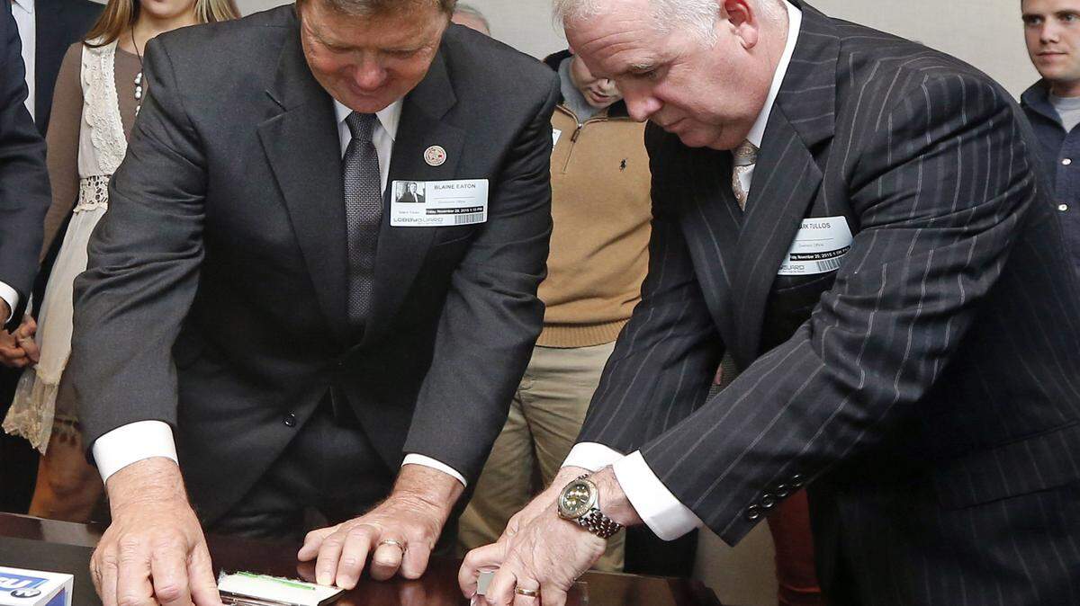 ROGELIO V. SOLIS/ASSOCIATED PRESSRep. Bo Eaton, D-Taylorsville, left, a 20-year incumbent, and Republican challenger Mark Tullos of Raleigh open and display the contents of silver-plated business card boxes in the governor's office near the state Capitol on Nov. 20 in Jackson. Eaton picked the one with the longer, 3-inch green straw, giving him the victory and blocking the GOP from having a supermajority in the House. The candidates were tied after the Nov. 3 election.