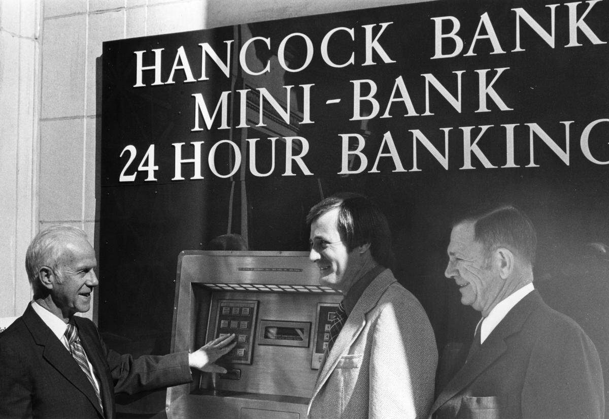 Donald Sutter, Hancock Bank executive vice president, left, board of directors member Roland Weeks, center, and senior vice president Tom Milner celebrated the introduction of automated teller machines to the Coast in 1973 at their Mini-Bank location at Edgewater Mall in Biloxi.