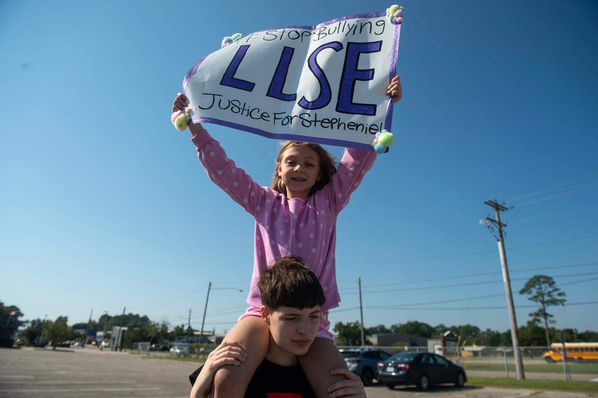 Kiersten Ellis holds Darlene Powers, on her shoulders in the parking lot of Warrior Stadium in D’Iberville on Wednesday, Oct. 9, 2024. The Powers and Ellis families have been making signs and drawing awareness to the bullying Stephenie “Stevie” English endured before she died by suicide on Sept. 22.