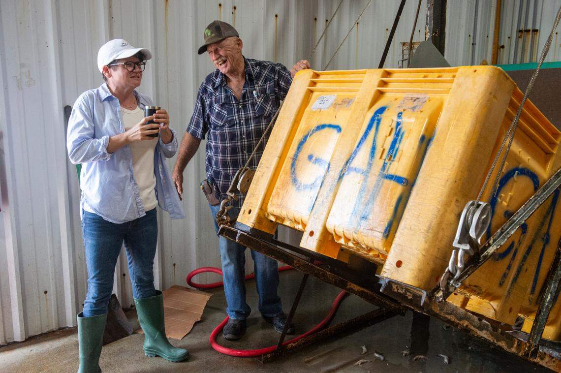 Ocean Springs Seafood Director of Operations Bethany Fayard, left, and factory manager Ken Lee unload a carton of shrimp to be processed inside Biloxi Bay Processing in Biloxi on Friday, May 31, 2024. Fayard’s father, Earl Fayard Jr., who owns Ocean Springs Seafood, part owns the processing factory, Biloxi Bay Processing, which opened in 2020.