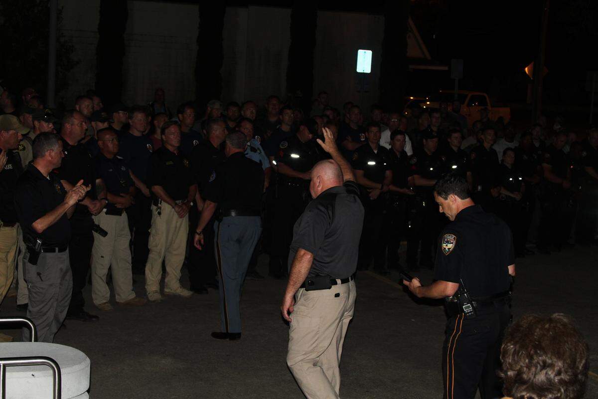 Biloxi Police Chief John Miller waves to exhausted officers after Darian T. Atkinson was arrested and brought to the public safety center for questioning in the slaying Sunday of Biloxi police Patrolman Robert McKeithen. Atkinson is charged with capital murder.