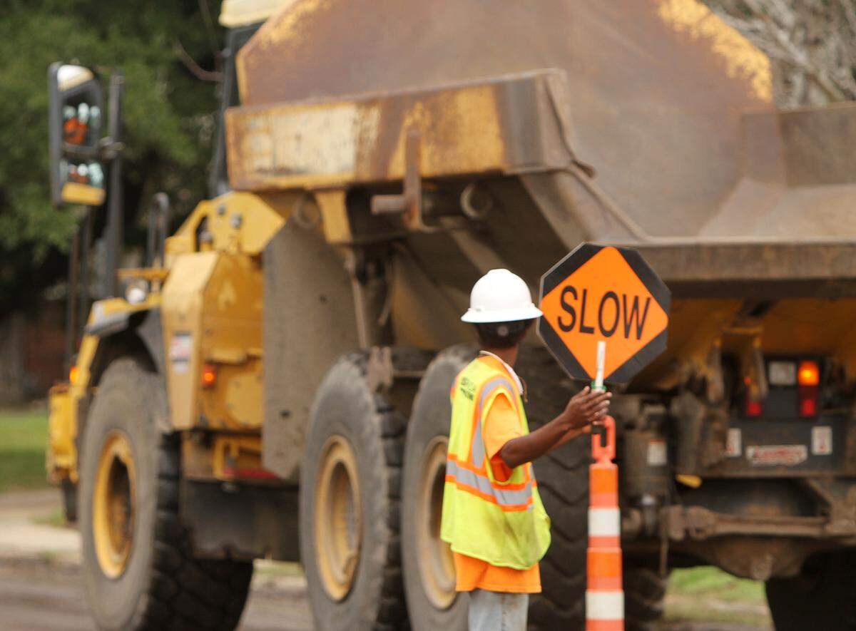 JOHN FITZHUGH/SUN HERALD An employee of Oscar Renda Contracting directs traffic around a work zone on Division Street in Biloxi on Monday Nov. 2, 2015.