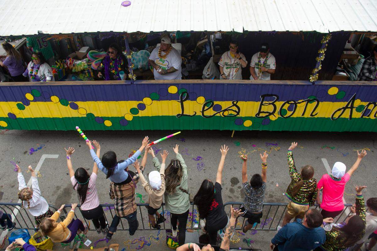 Parade watchers cheer for beads and other throws during the Gulf Coast Carnival Association Mardi Gras parade in Biloxi on Tuesday, March 4, 2025.