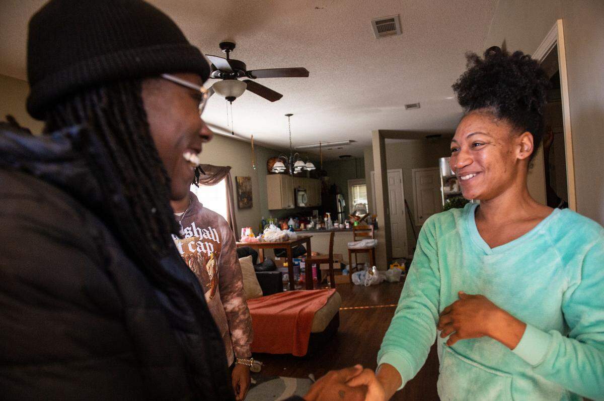 Olympian and Gulfport High School track coach Brittney Reese shakes hands with Tanaya Smith, a caterer from Gulfport, as Reese and rapper J. Lock deliver Christmas presents to Smith’s kids at Smith’s home in Gulfport on Friday, Dec. 23, 2022.