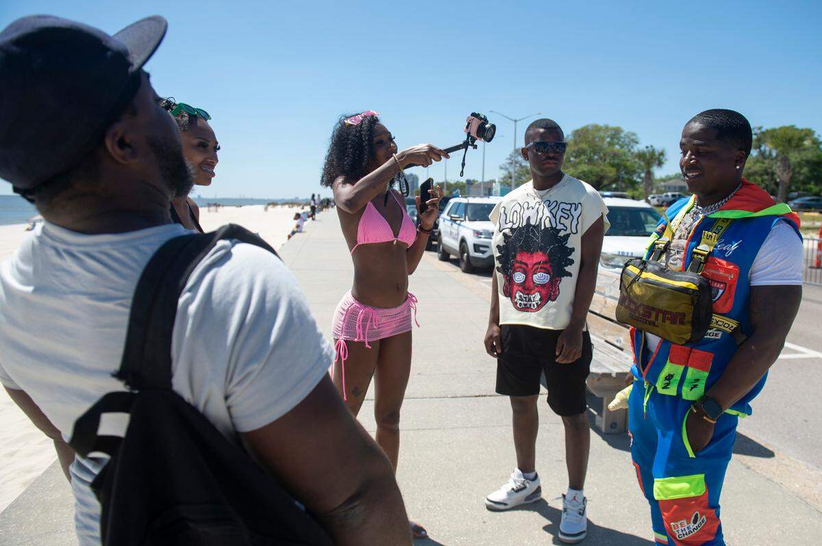 Beachgoers film an interview blog during Black Spring Break on Saturday, April 12, 2025.