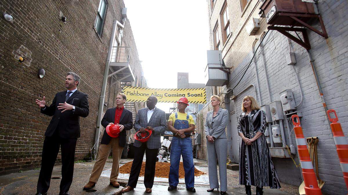 AMANDA McCOY/SUN HERALD 
 David Parker, the economic director for the City of Gulfport, left, speaks while standing with other officials in Fishbone Alley for a groundbreaking ceremony on Wednesday, December 16, 2015, in downtown Gulfport. The project will transform the alley into an attractive pedestrian walkway and destination.