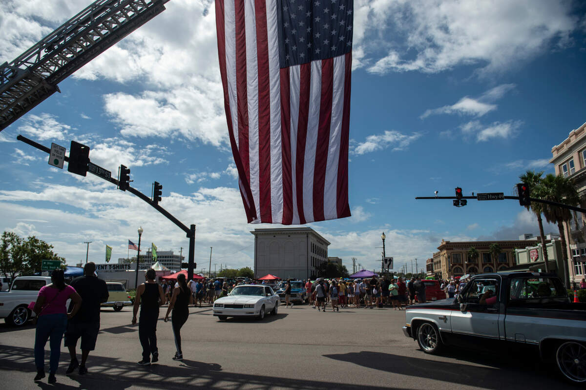 Pedestrians and classic cars pass over Highway 49 during View the Cruise in downtown Gulfport on Sunday, Oct. 3, 2021.