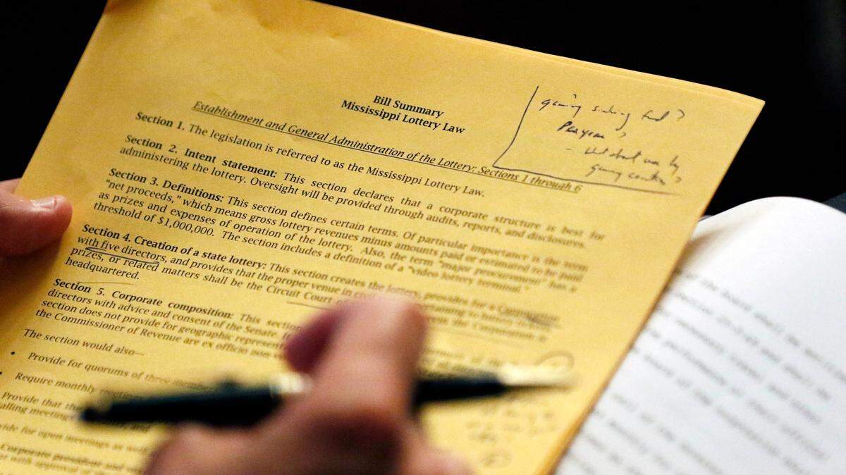 A senator reads over a bill summary of the proposed Mississippi Lottery Law, as the legislation is presented before the body in Senate Chambers, Thursday, Aug. 23, 2018, at the Capitol in Jackson, Miss. Republican leaders have outlined a package to divert existing tax revenue, take on debt and create a lottery.