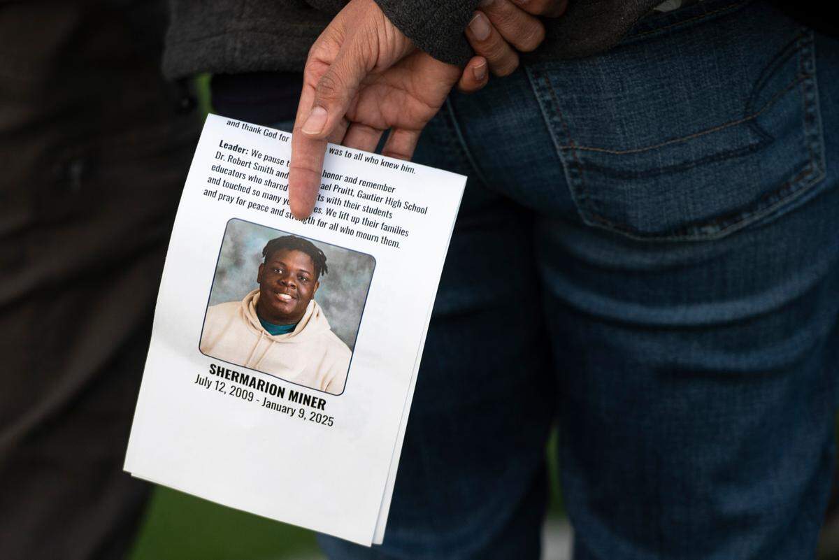 A mourner holds a program during a vigil for Gautier High School student Shermarion Miner at Gautier High School on Thursday, Jan. 16, 2025.