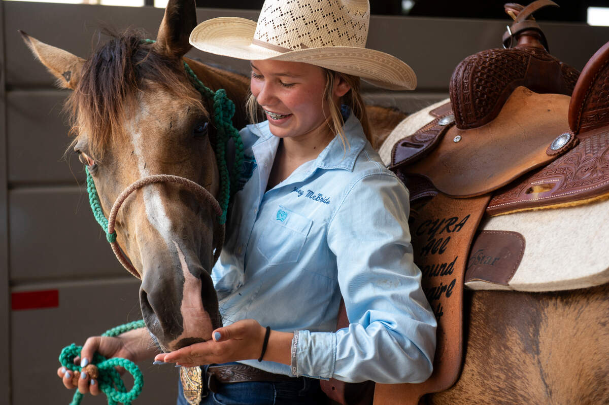 Kinsley McBride feeds her horse Houdini after practicing barrel racing at the Harrison County Fairgrounds on Thursday, June 13, 2024.