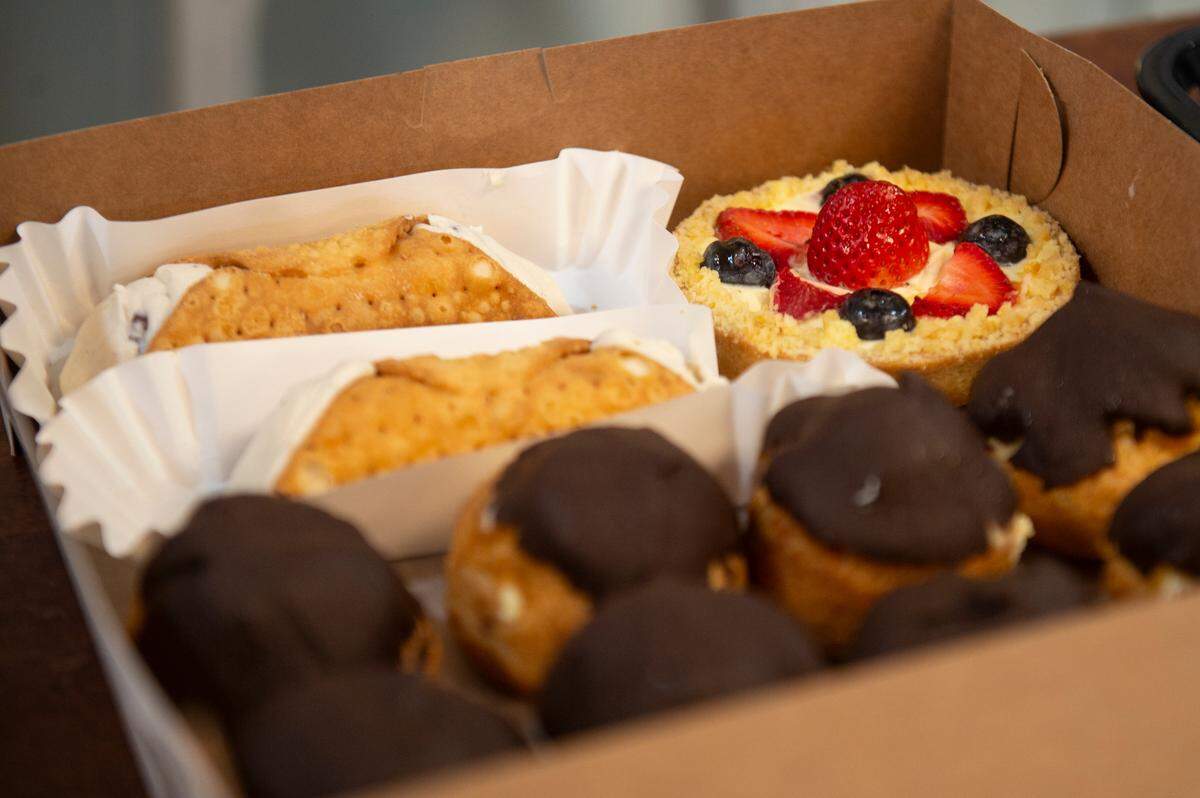A tart, eclairs and cannolis are packed for a customer at Harvest Bay Artisan Bakery in Bay St. Louis on Thursday, Dec. 7, 2023.