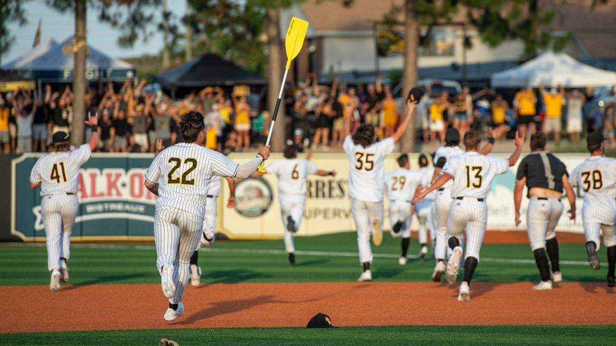 Southern Miss’s Charlie Fischer carries the rally paddle as Southern Miss runs towards the rooster after defeating LSU in the NCAA Regionals at Pete Taylor Park in Hattiesburg on Monday, June 6, 2022.