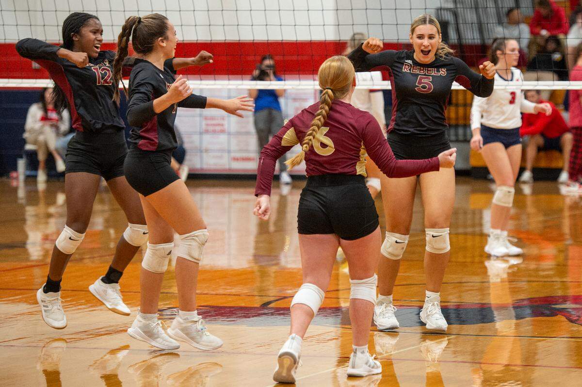 The George County Rebels volleyball team celebrates after a point during the 6A South State Championship game at Hancock High School in Kiln on Monday, Oct. 16, 2023.