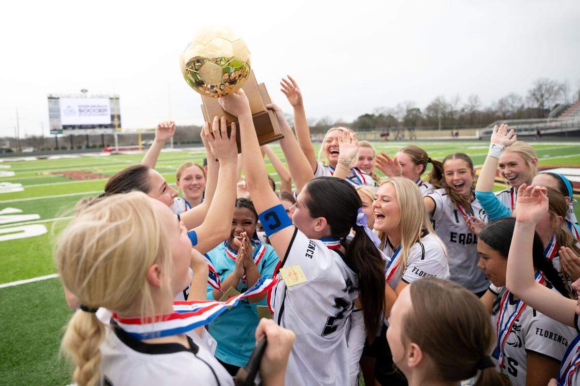 Florence players hoist the state championship trophy after winning a 5A girls soccer state championship game.