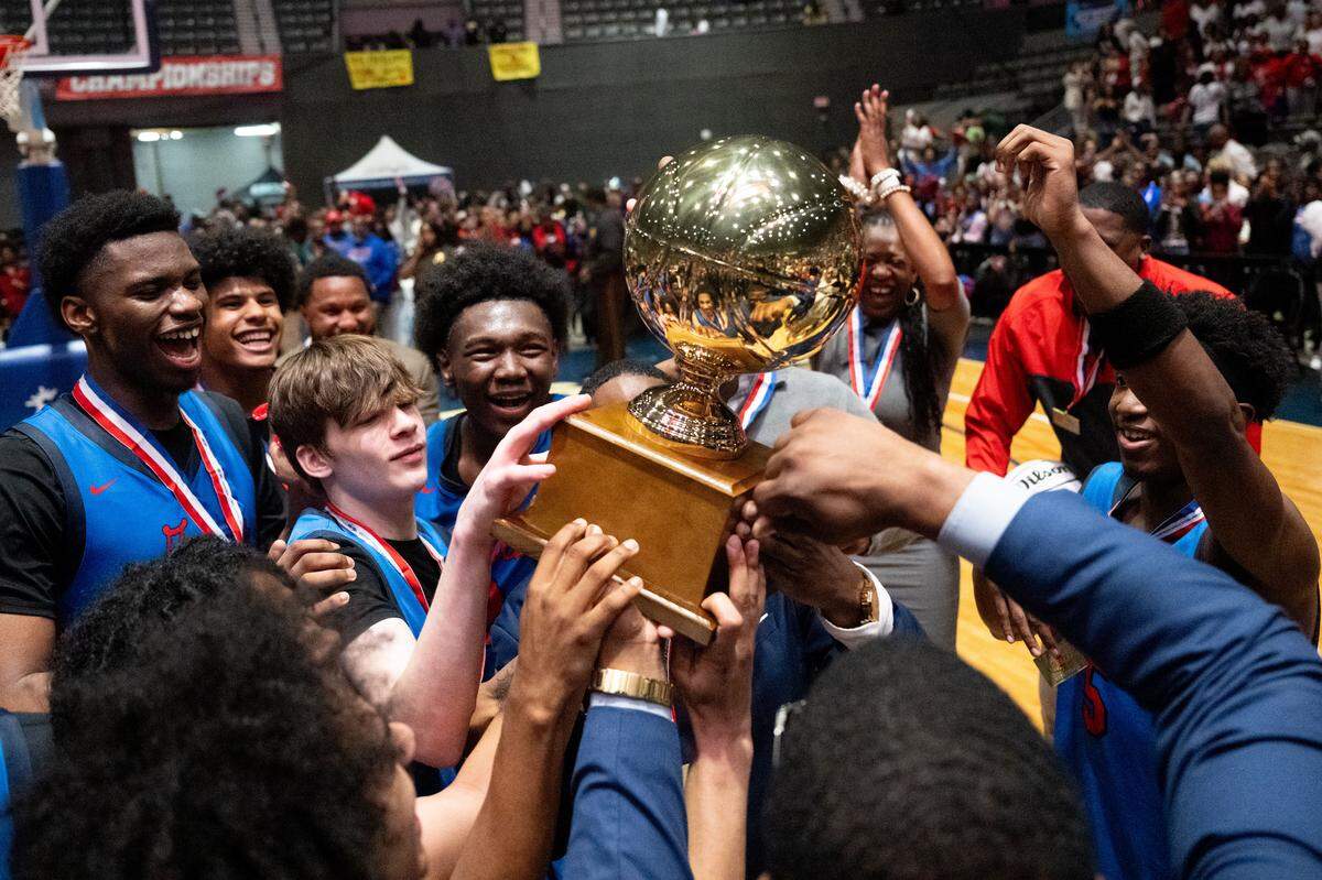 Pascagoula players hoist the state championship trophy.
