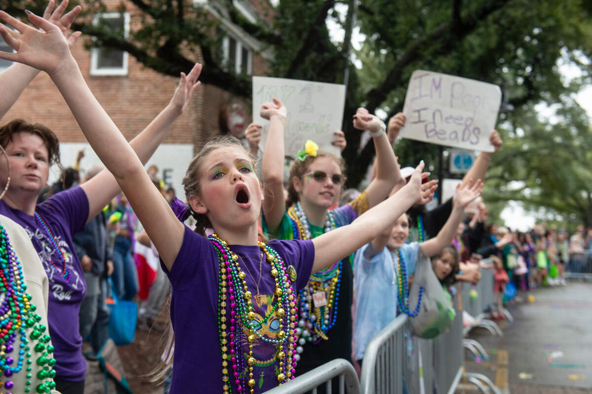 Parade attendees cheer for beads during The Ocean Springs Elks Carnival Parade in downtown Ocean Springs on Saturday, Jan. 27, 2024.