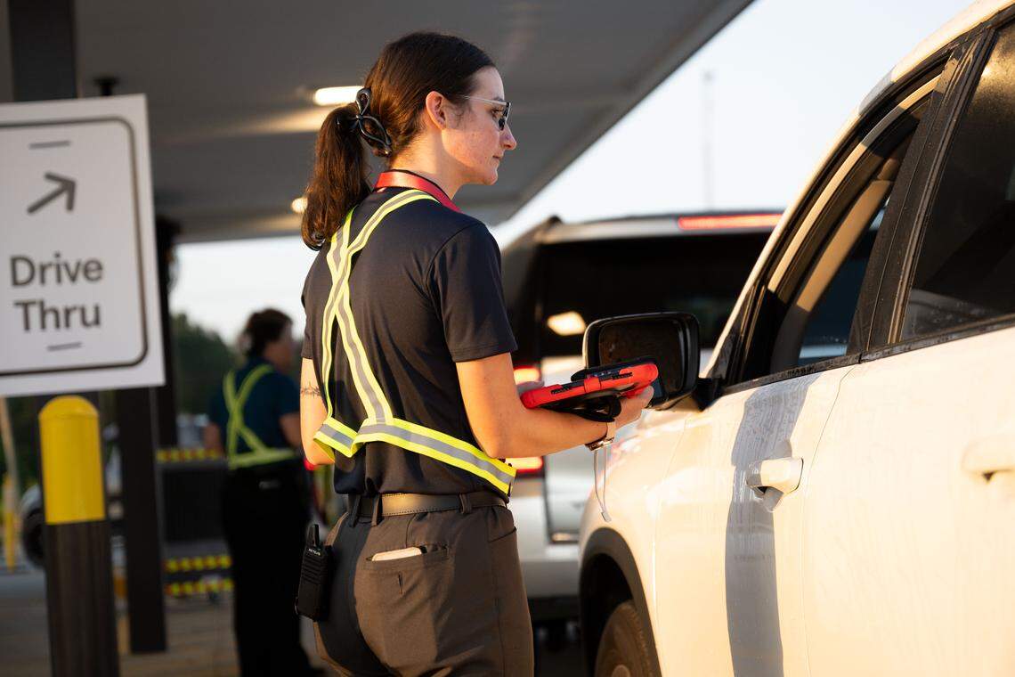 A Chick-fil-A employee takes one of the first drive-thru orders Thursday.