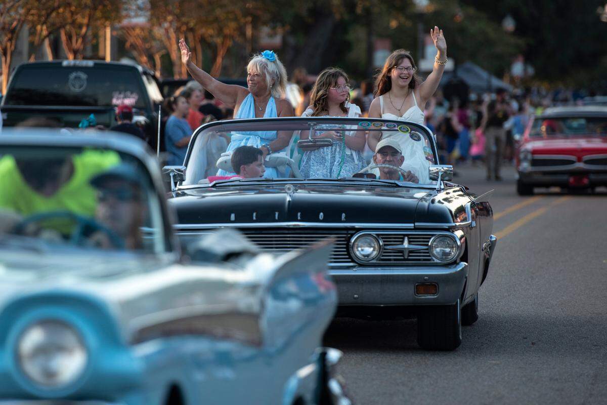 Cruisers wave to the crowd during the Long Beach Parade in Long Beach in 2024. This year, an all-day car show will bring the vehicles and fans to Long Beach hours ahead of the start of the parade.