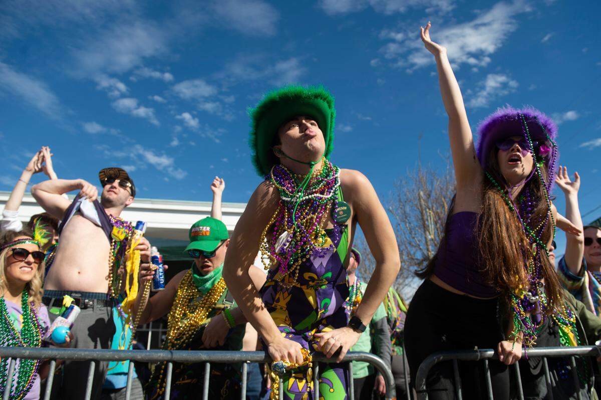 Paradegoers cheer for beads during the Gulf Coast Carnival Association’s Mardi Gras parade in Biloxi on Tuesday, Feb. 13, 2024.