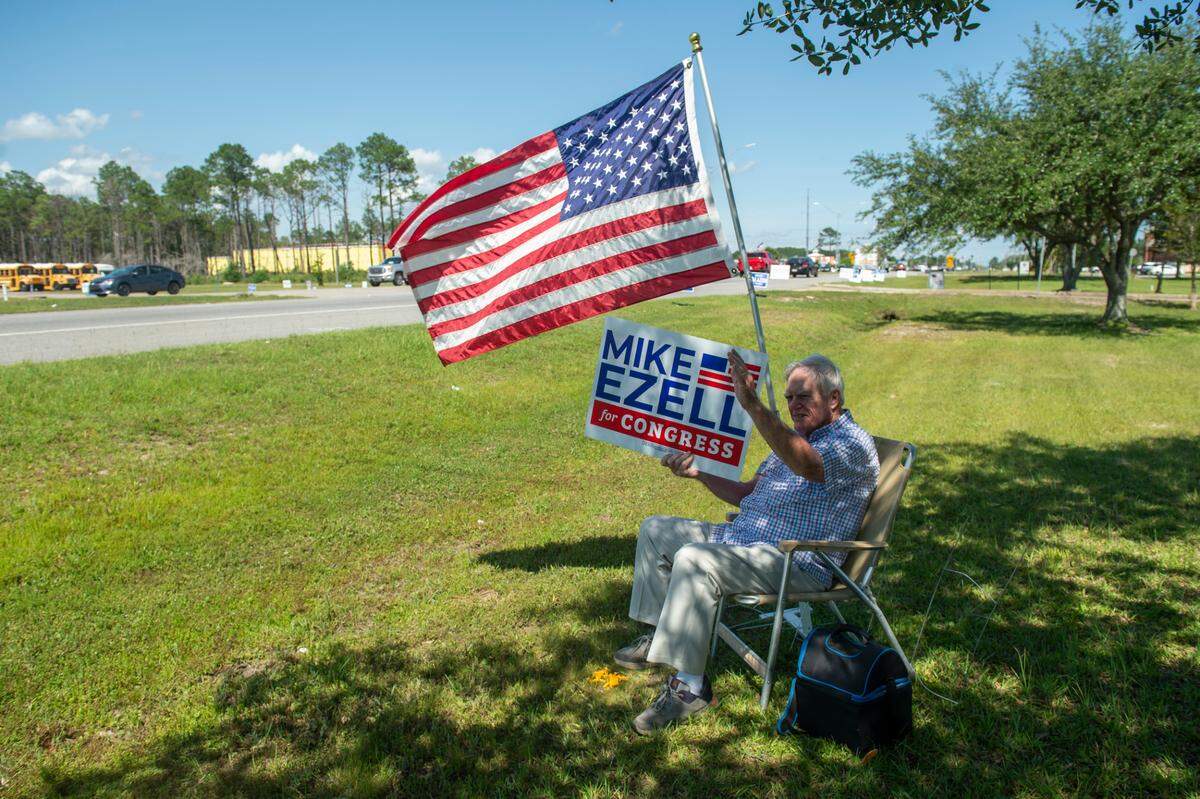 Carl King, a Deputy Chaplin at the Jackson County Sheriff’s Department, holds a sign supporting Jackson County Sheriff Mike Ezell’s bid for Congress outside the Ocean Springs Civic Center on Tuesday, June 7, 2022. King, who is friends and works with Ezell, said Ezell had his vote because he was, “a good Christian leader.”