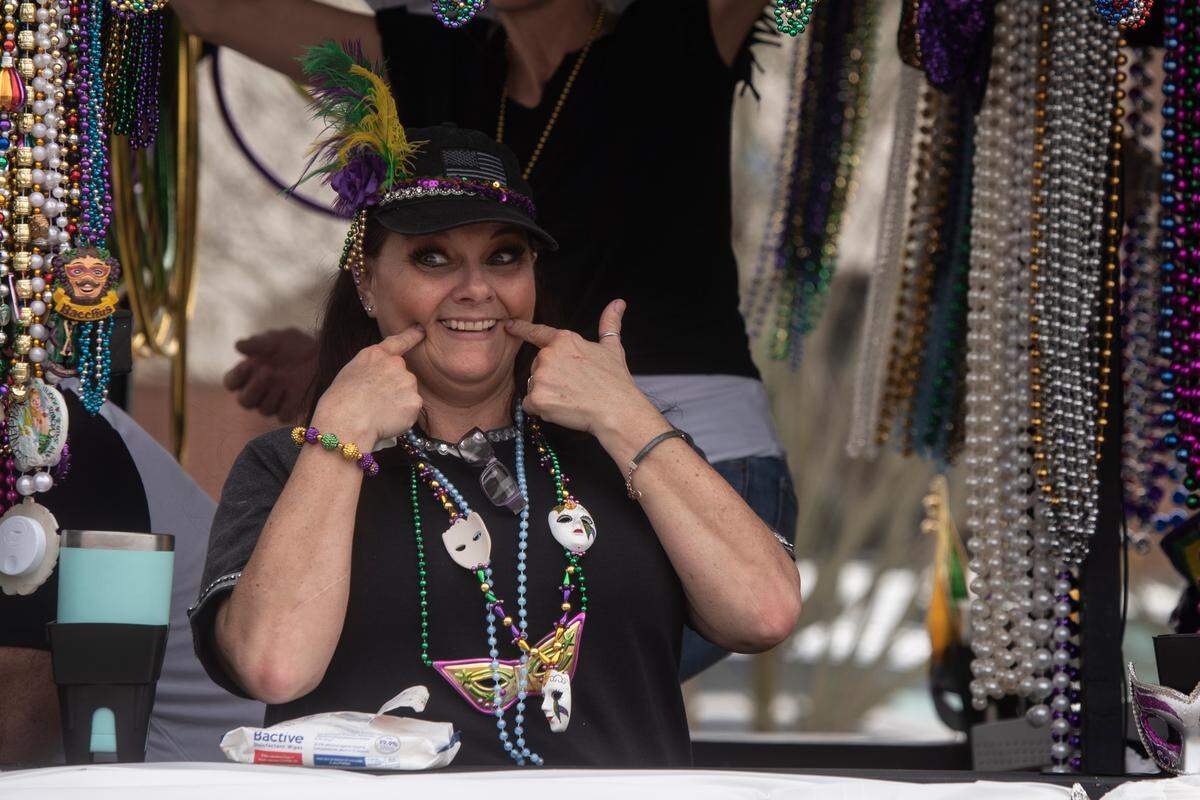 A float rider makes a smiley face during the Gulf Coast Carnival Association Mardi Gras parade in Biloxi on Tuesday, Feb. 21, 2023.