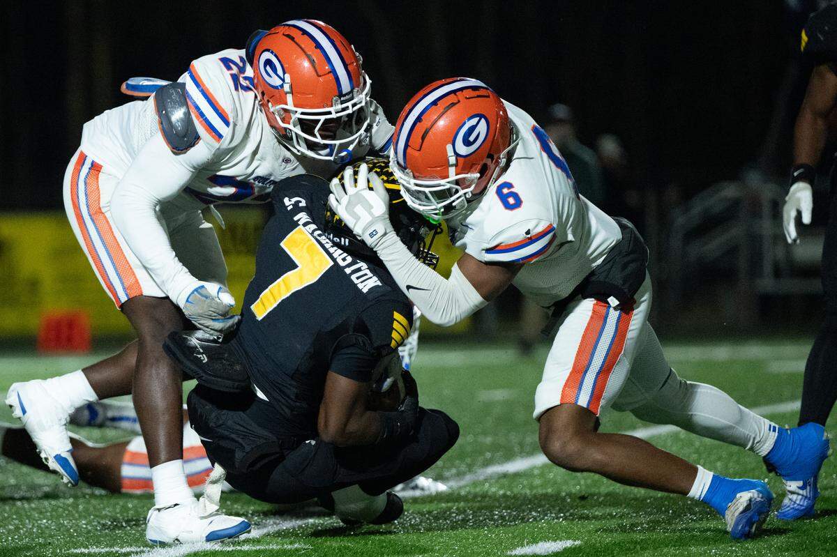 Gulfport linebacker Andre Peters III (22) and Cordarious Payton (6) tackle D’Iberville running back Caleb Washington (7) during the Admirals’ win earlier this season.